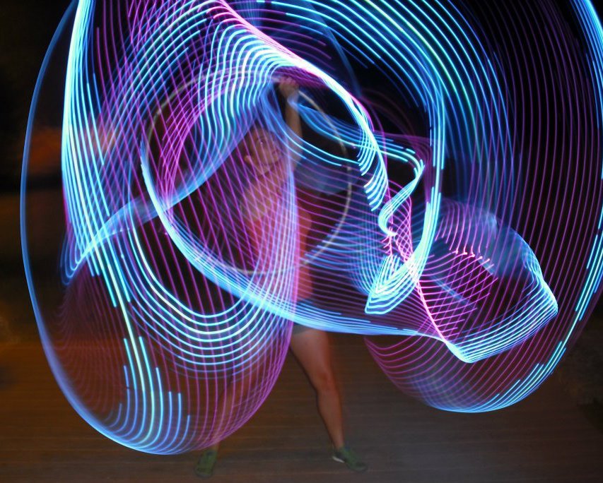 Photo of Carrie hooping at night with LED hoops!